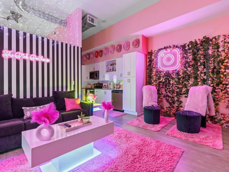 Pink neon-themed Airbnb living room reset and vacuumed between guests