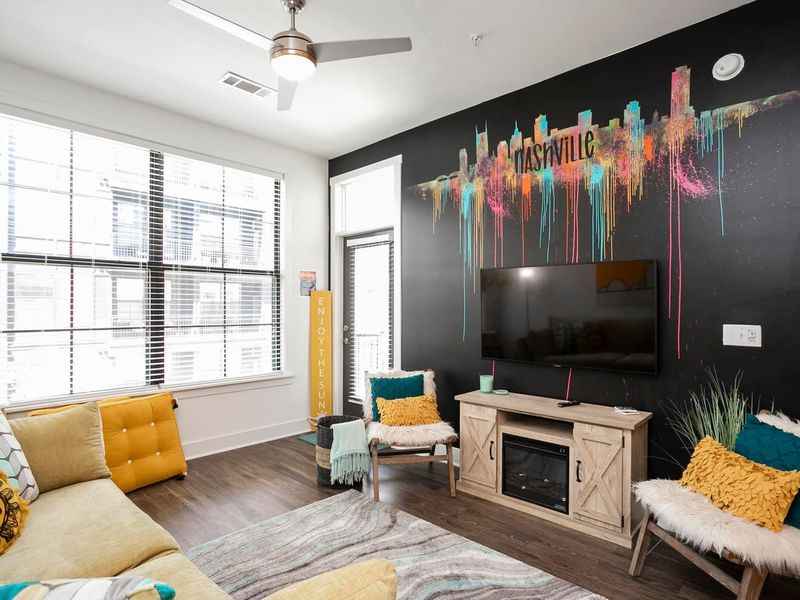 Open living room with colorful accent wall and fireplace, tidied after checkout