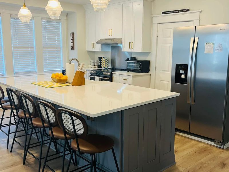 Kitchen with island seating and pendant lights, counters and floors cleaned