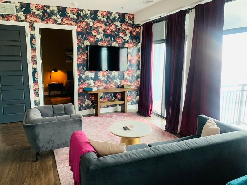 Floral-wallpaper living room with sofas and coffee table, reset for arriving guests