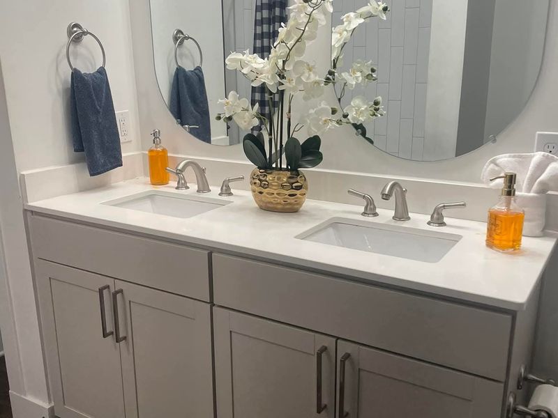 Double-sink bathroom vanity with polished mirrors and fresh towels